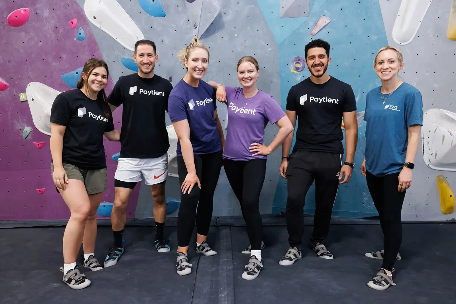 Paytient team wearing branded t-shirts at a climbing gym. US healthcare payments platform identity by WeGrow.