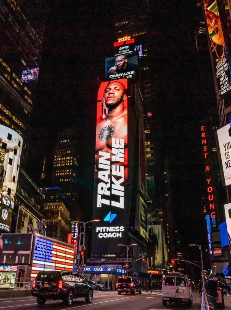 Fitness Coach logo on a Times Square billboard at night. Identity built for one of the largest fitness apps globally, by WeGrow.